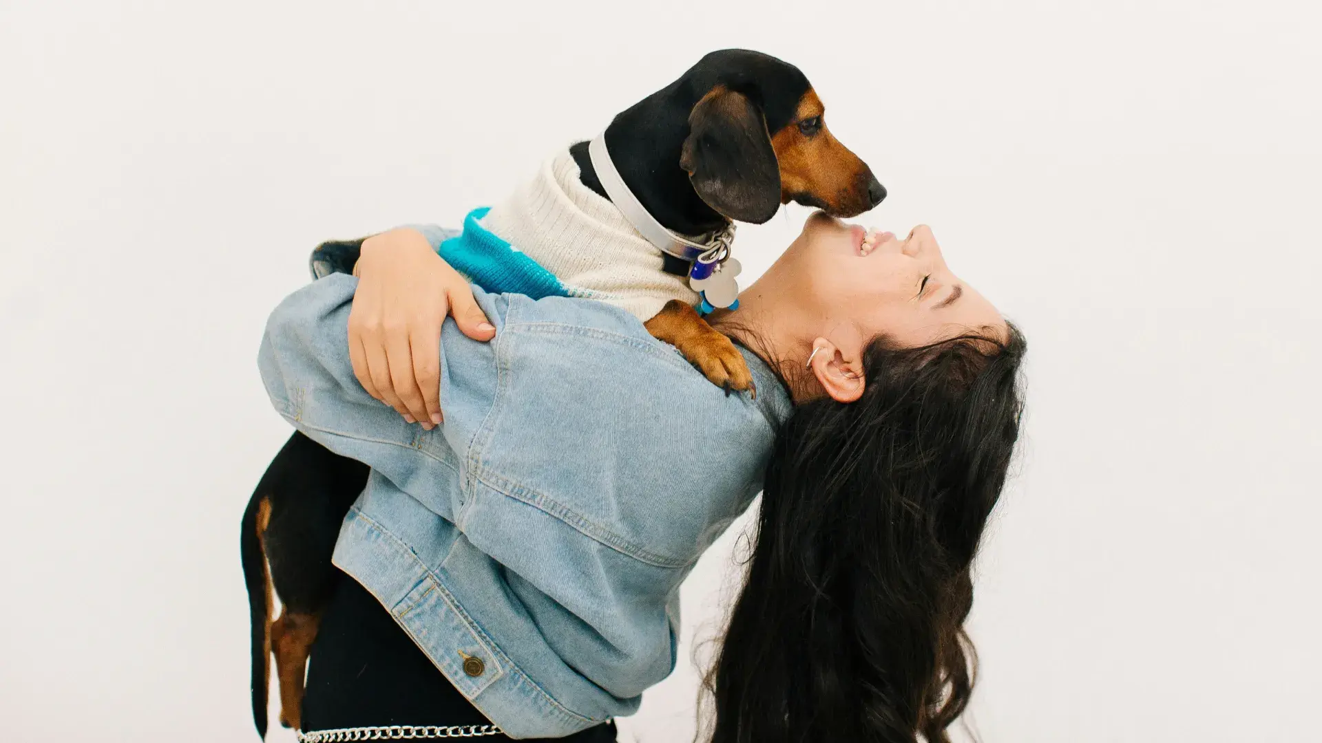 An affectionate black and tan dog leaning into its owner’s embrace, highlighting physical touch as a primary way dogs show love and devotion.